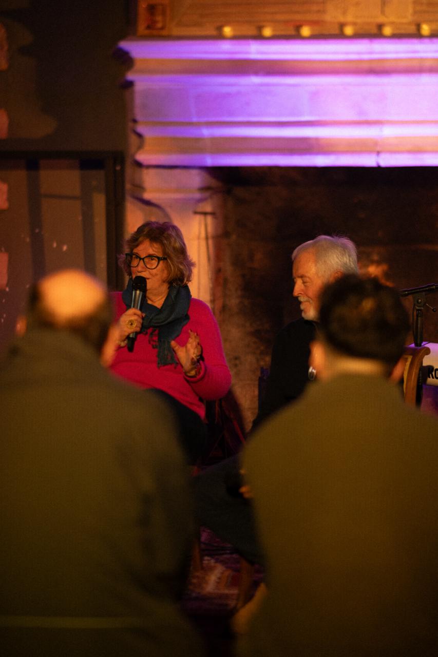 Catherine au micro, Philippe à ses côtés, lors d’une soirée au coin du feu